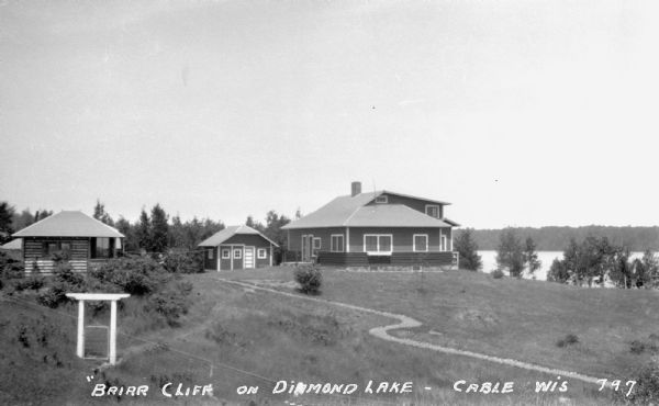 House, garage, and cottage on shoreline of Diamond Lake.