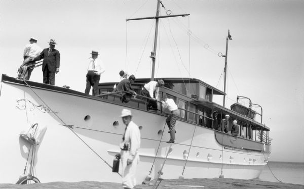 Men and sailors on board the large cabin cruiser "Lamora" at dock on Lake Superior.