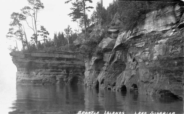 View from water of sandstone cliffs and caves on Lake Superior shoreline.