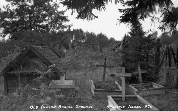 Wooden burial house, plots and crosses surrounded by wooden fence on Madeline Island.