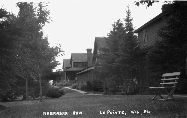 Sidewalk in front of four houses along Nebraska Row at Madeline Island. Nebraska Row was started by Col. Frederick Woods in 1899 on the bluff at the western edge of La Pointe.