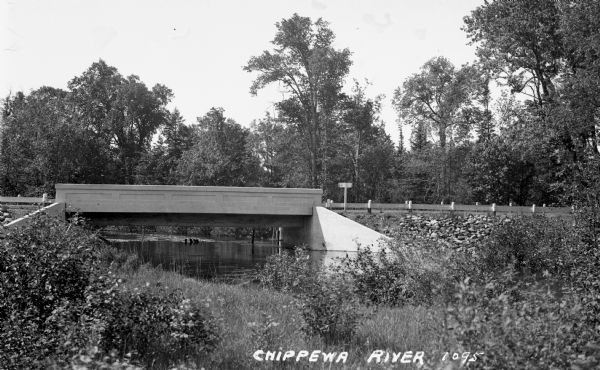 View from side of river of cement bridge over the Chippewa River in Sawyer County, possibly on County Highway B.