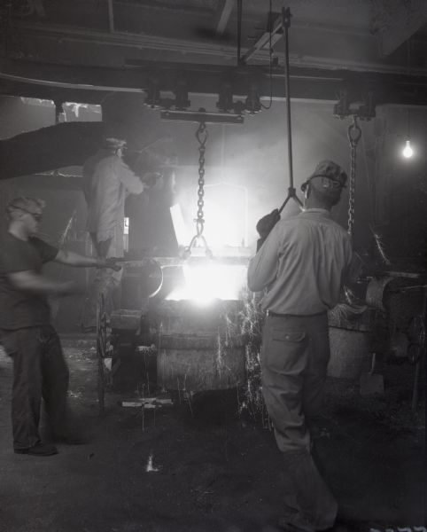 Joe Weyenberg and two other men work with molten metal at the Roloff Manufacturing Company.