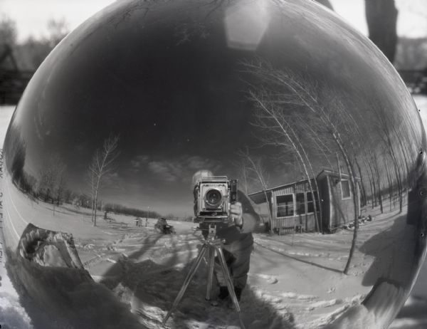 "On Groundhog Day, Andrew J. Mueller went out early with his camera and set up a crystal ball to aid the groundhog in his predictions. He set up the camera and got a winter scene, his own reflection in the crystal, but no groundhog."