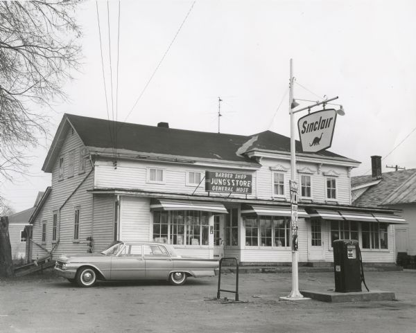 Exterior of Jung's General Store/Gas Station/Barber Shop. The station's sign advertises Sinclair brand gas.