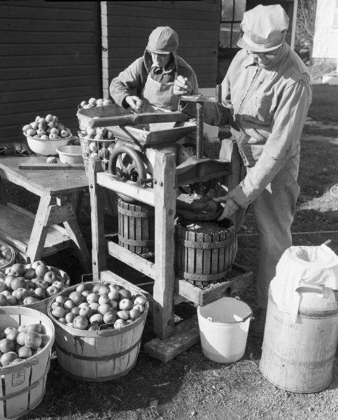 Louis Suttner and another man making apple cider.