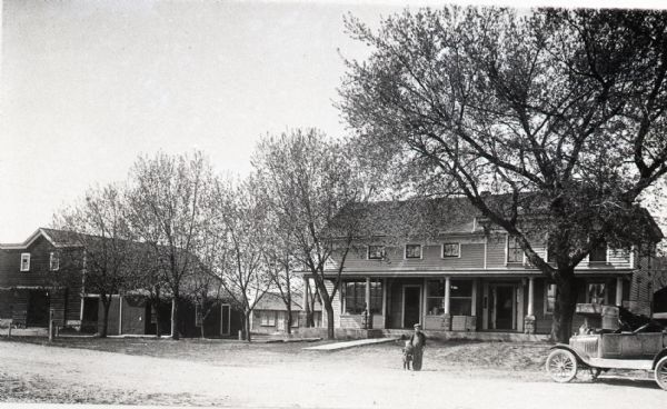 Copy photograph depicting a man and boy standing in the road. This location would later become the site of Jung's General Store.