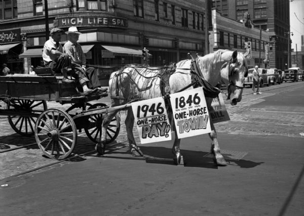Horse-drawn wagon in a United Public Workers Parade/Demonstration through downtown. The horse bears signs that read "1946 One Horse Pay!" and "1846 One Horse Town."