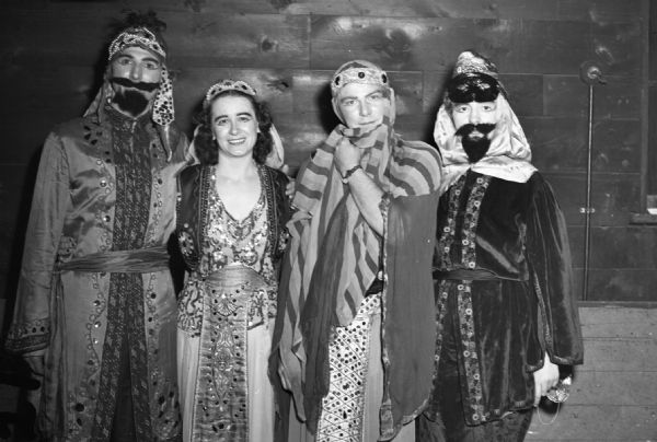 "Arabian" group at the Harnishfeger Masquerade Ball wearing embroidered and sequined costumes, eye makeup, fake beards and moustaches.