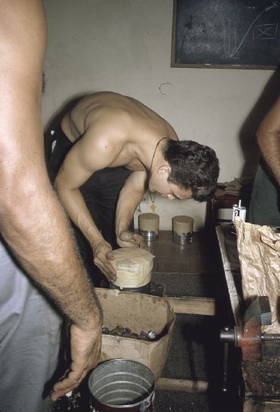 Member of the anti-Castro group, Commandos L, putting covers over newly manufactured explosive devices.