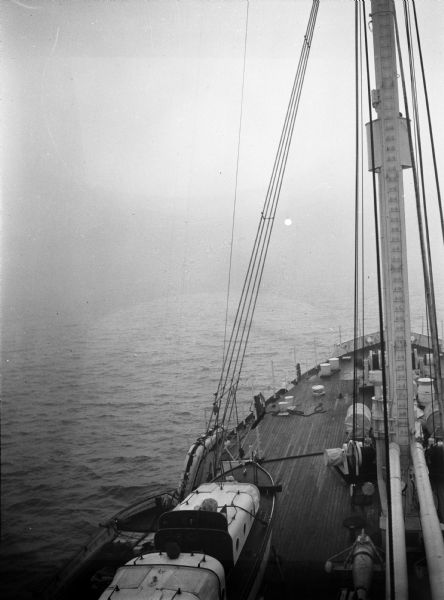 The sunrise aboard the USS <I>Relief</I> in the China Sea. The mast and bow of the ship are pointed eastward, into the fog and towards the rising sun.
