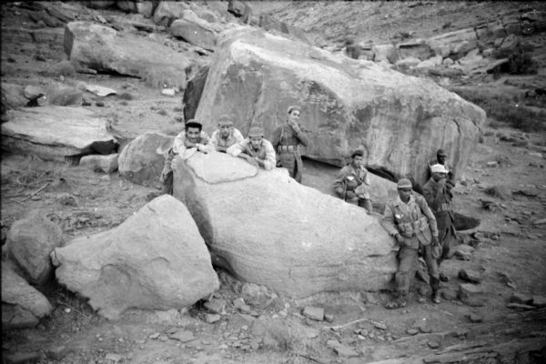 Algerian members of the National Liberation Front posing by large boulders.