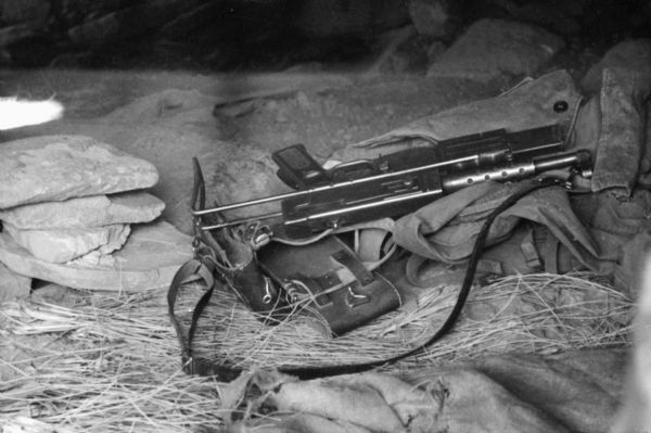 A sub-machine gun owned by a National Liberation Front member in Algeria. The gun is on top of a pile of clothes inside a cave.