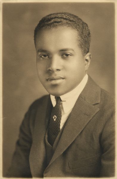 Quarter-length studio portrait of Andrew Webb Jr. wearing a suit and tie, with a tie tack and collar pin.