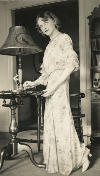 Irene Steinkopf, motion picture editor of the Milwaukee Sentinel, dressed in a floor-length gown for an evening on the town.