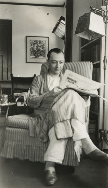 Still wearing his pajamas, "Milwaukee Sentinel" editor Alvin Steinkopf reads the newspaper.  The popular comic strip, "Gasoline Alley," can be seen on the back of the section he is holding. This photograph was probably taken by Steinkopf's wife, Irene.