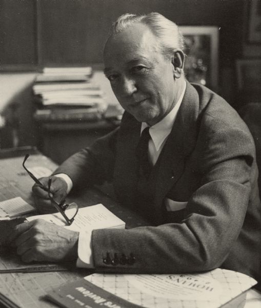 Informal portrait of Associated Press journalist Alvin J. Steinkopf seated at his desk in the London bureau.