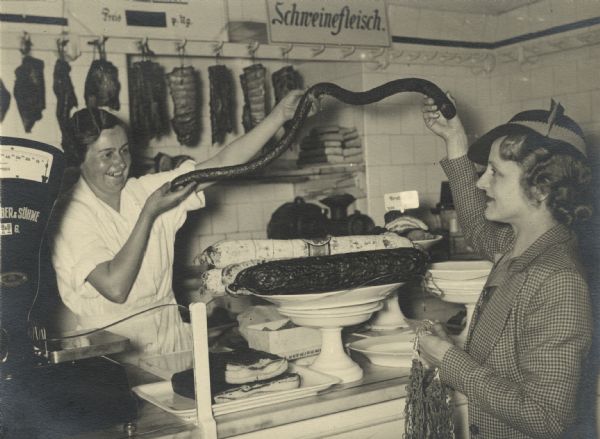 Irene Steinkopf, a former Milwaukee journalist, shops for sausage in Vienna where her husband had been assigned by the Associated Press. A bit much for two persons, she says to the butcher, and she settles for six hot dogs. In her album, Irene wrote, hot dogs were called frankfurters in Vienna; a "wiener" is a Viennese man.