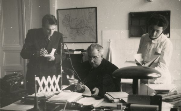 Dr. Edward L. Miloslavich (center), formerly a Milwaukee police surgeon, seen here in his office in Zagred, Yugoslavia. Dr. Miloslavich played a role in the international investigation of the Katyn Forest massacre.
