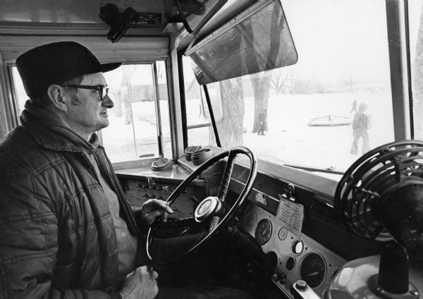 "School bus driver Aaron Henning waits patiently for his passengers."
