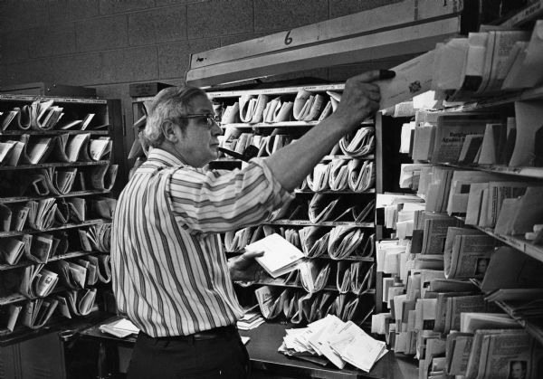 "U.S. Post Office. Rural mail carrier, Ralph Koll, sorts the mail prior to beginning his route."