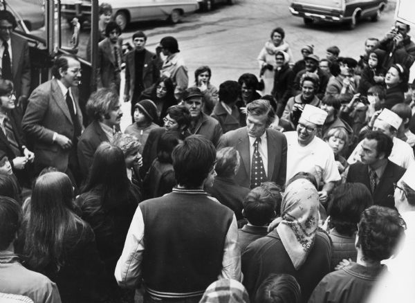 "As Mayor John Lindsay leaves the bus, he is mobbed by onlookers, and greeted by John Widmer."