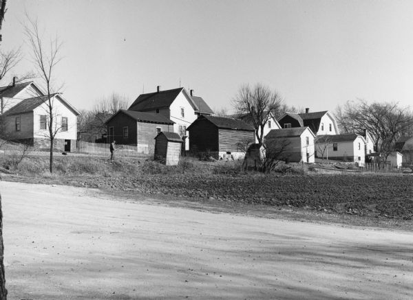 "These houses on Church Street were photographed from the intersection of Henni & Wisconsin Streets. Note the outhouses!"
