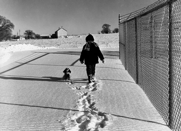 "Brenda Widmer walks her dog Bonnie next to the disposal system. In distance is Sunny Brae farm, site of present-day Schnitzler River View Hills mobile home park."