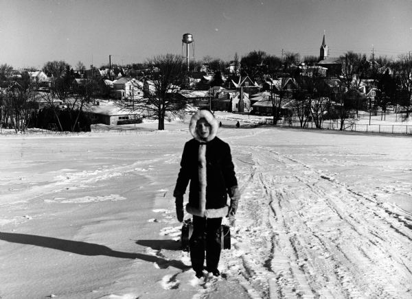 "Kay Widmer pulls her toboggan up the hill that is on the southwest edge of the village."