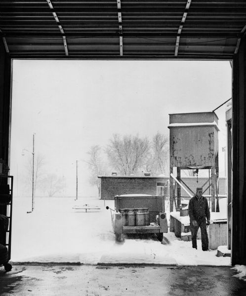 "Paul Koll loads empty milk cans at Widmer Cheese Factory."