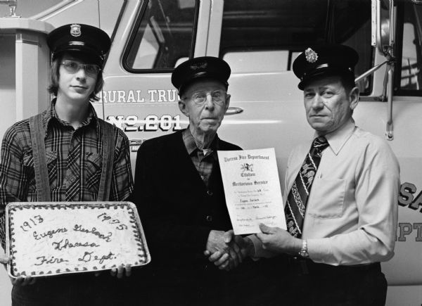 "Eugene Gerlach is honored for his many years in the Fire Department.  He is flanked by his grandson, Gene Koll, & Chief Bernard Adelmeyer."
