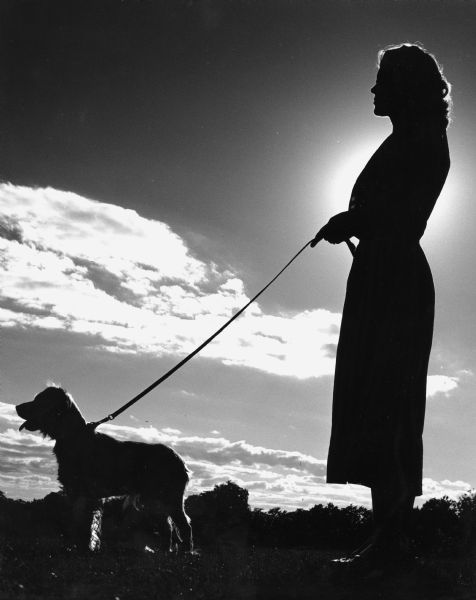 Eunice Lamers and her pet are silloutted by the late afternoon sun.