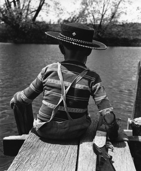 The little cowboy with a toy gun on the pier is John Paul Widmer. The pier was on the Rock River at the west end of Henni Street in Theresa.