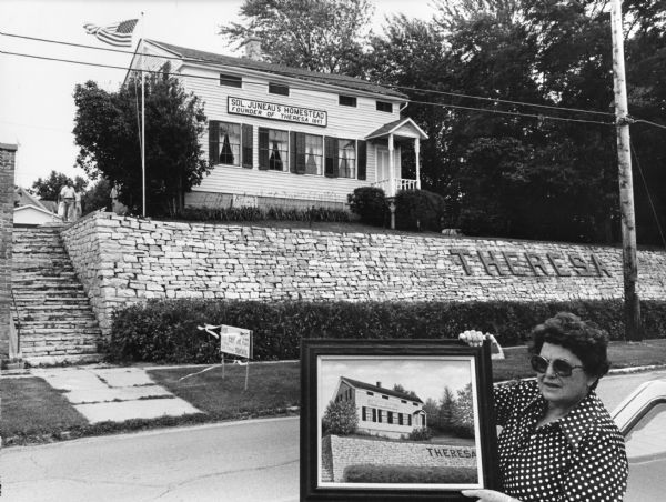"Betty Zedler, artist, poses with her painting of the Solomon Juneau House."