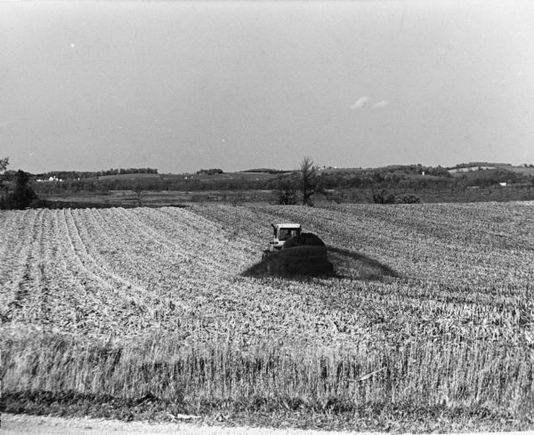 View of a tractor fertilizing crops in a field.