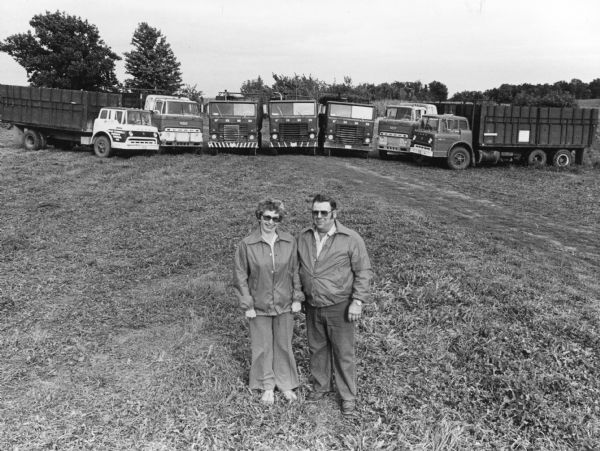 "Ken & LaVerne Schoebel pose with their fleet of trucks."
