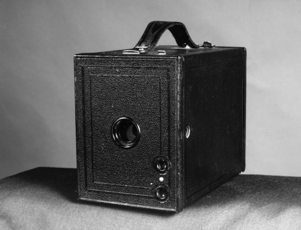 "In the 30s every home had a Kodak box camera. (The plate on the front of this camera is flipped.) The two circular windows should be on upper left."<p>In the 1920s and 30s the venerable Eastman Kodak box camera became a staple in many households.  The camera was easy to use and produced fairly good pictures.  The main instruction for its use was "when taking a picture always have the sun at your back!!"