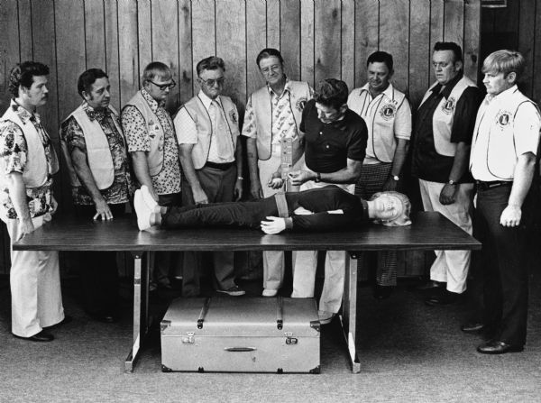 "Theresa Lions purchased this 'Annie' to practice CPR. Members are Bernie Adelmeyer, demonstrating, from left: Jim Wiseman, Ed Guelig, Neil Coulter, Harvey Bogensneider, Wally Sauer, Carl Bernhard, Jerry Musack, Gary Erdman."