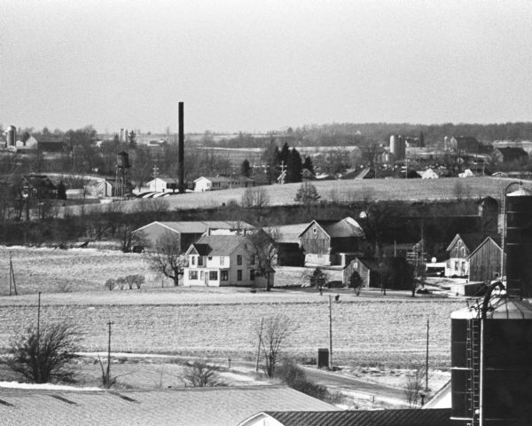 View of farmland featuring farmhouses, barns, and a water tower.
