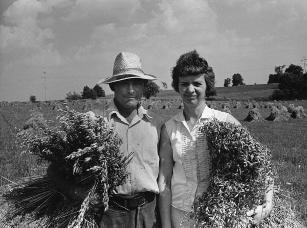 "Gerald and Grace Batzler are holding shocks of grain at their farm on Midland Road."