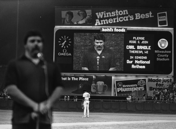 "With 15,331 fans looking on at the Milwaukee Brewers last home game of the season at County Stadium, Carl 'Bear' Bandle belts out our national anthem."