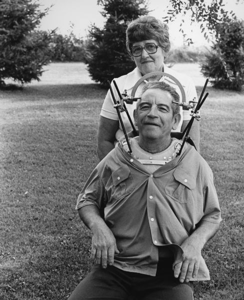 "While vacationing at Cable, WI, Ernie Kallsen sustained a broken neck after diving into shallow water. Ernie, pictured with his wife Lill, had to wear a neck brace for twelve weeks."