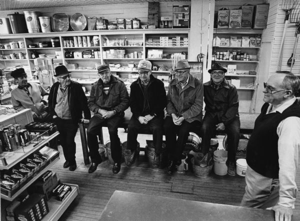 "A 'Hot Stove League' has evolved as locals meet daily in Russ Bandlow's Hardware Store. From left are Junior Guelig, Par Wagner, Sep Hartman, Fritz Giese, Pete Bodden, Bob Fransen, and Russ Bandlow."
