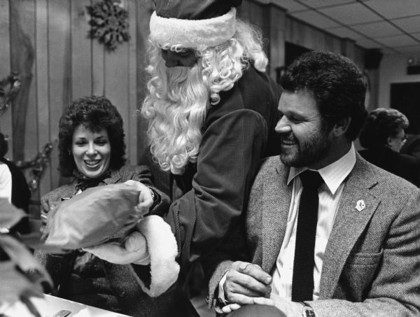 "Santa Claus pays a visit to Marlene and Chuck Bernhard at the American Legion Christmas Party."