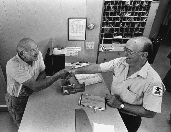 "Dr. Greg Langenfeld congratulated Postmaster Paul 'Skip' Trauba when the new Theresa Post Office was opened."