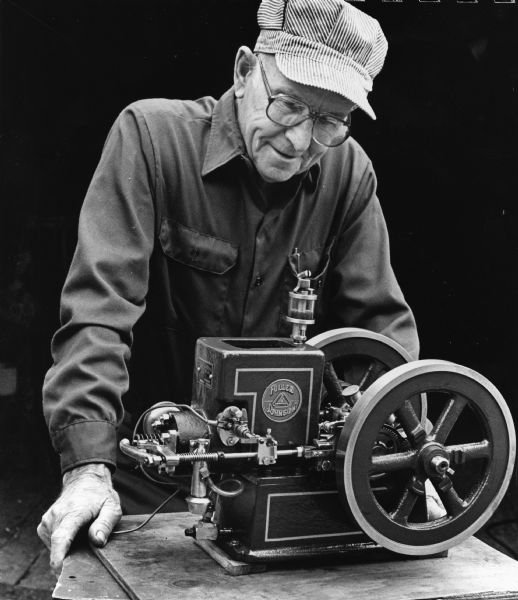 "Arnold Hartmann, Mayville, displays a 1/3 scale model Fuller & Johnson gas engine. The engine was machined by Arnie in his elaborate machine shop."