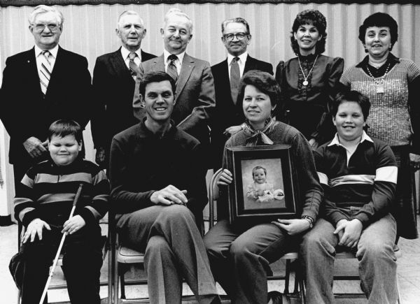 "The Ron Bernhard family, seated, who lost their young daughter, received aid from AAL Insurance of Appleton. Representatives are in back."