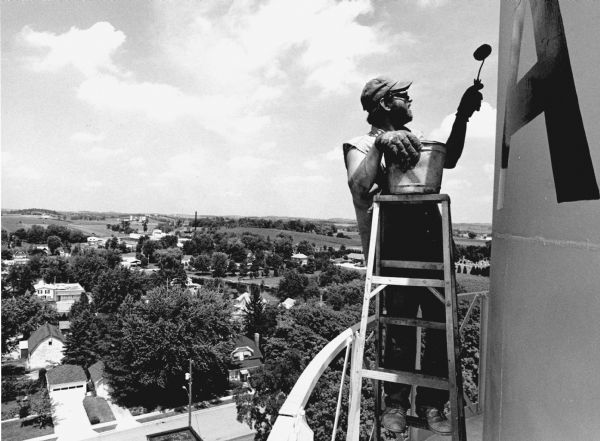 "This workman is painting 'Theresa' on the water tower."