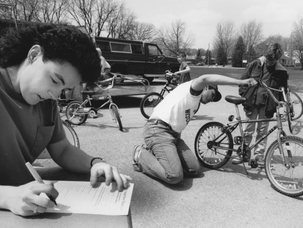 "A bicycle clinic was held for young bikers at the Theresa Public School grounds. While Chris Graf registered, her husband Joel checked bicycles."