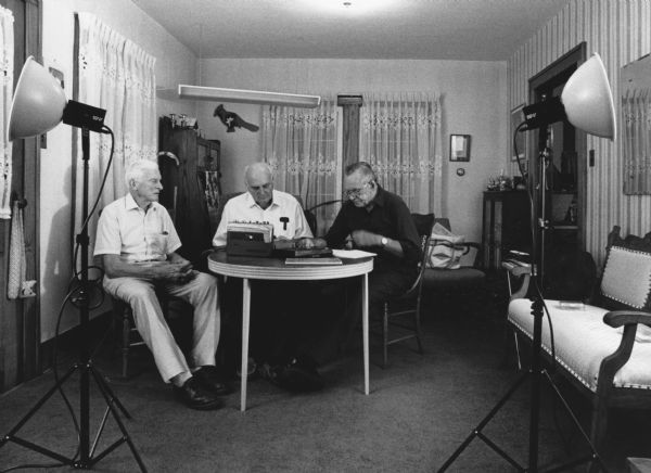 "With tape recorders catching every word, Les Beck, right, reads from his mother's diaries. Ralph Widmer, left, and Fred Bandlow, center, add to their vivid recollections. The diaries covered a span of years from 1934 through 1957. The three have amassed a total of 228 years of living in the village."